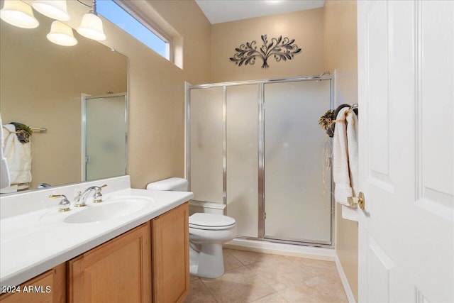 bathroom with toilet, tile patterned flooring, a shower with shower door, and vanity