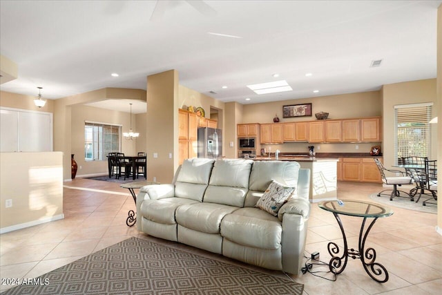 tiled living room featuring a notable chandelier