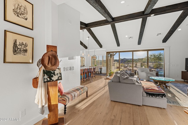 living room with light hardwood / wood-style floors and beamed ceiling