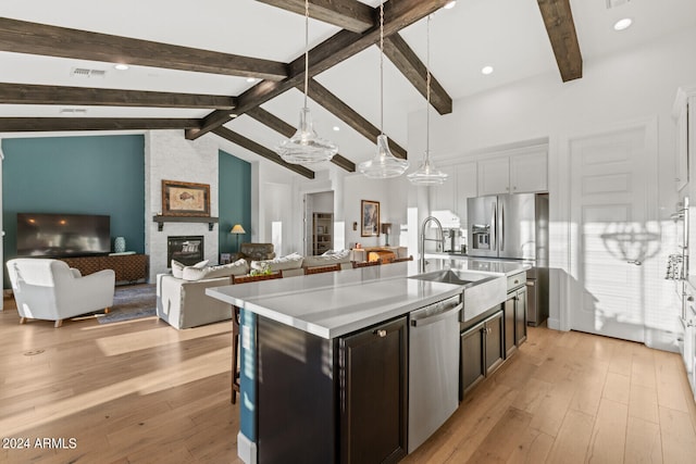 kitchen featuring white cabinets, an island with sink, stainless steel appliances, and light hardwood / wood-style flooring