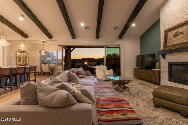 living room with a fireplace, beam ceiling, and high vaulted ceiling