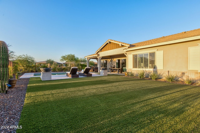 rear view of house featuring a swimming pool, an outdoor hangout area, a patio, and a yard