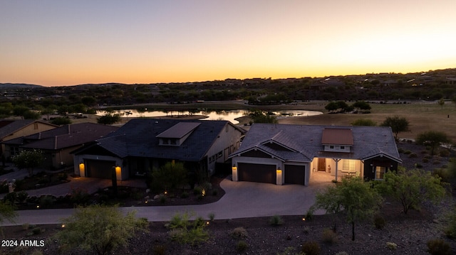 aerial view at dusk featuring a water view