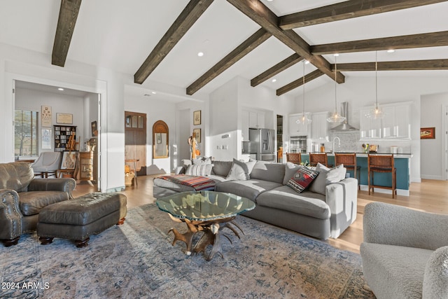 living room featuring sink, beam ceiling, and light hardwood / wood-style floors