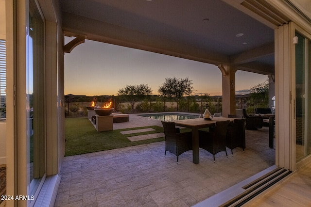 patio terrace at dusk featuring a fenced in pool and a yard