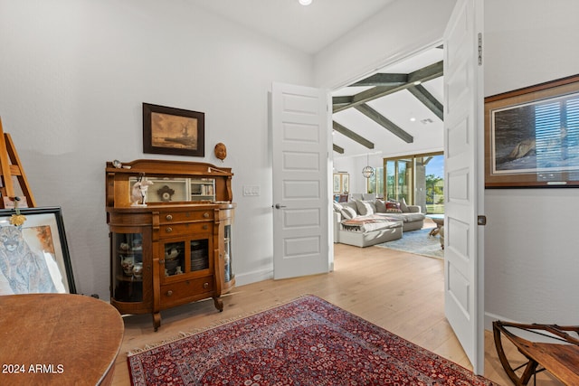 interior space featuring beamed ceiling and light hardwood / wood-style flooring