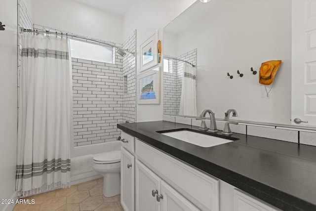 full bathroom with vanity, shower / bath combo with shower curtain, toilet, and tile patterned flooring