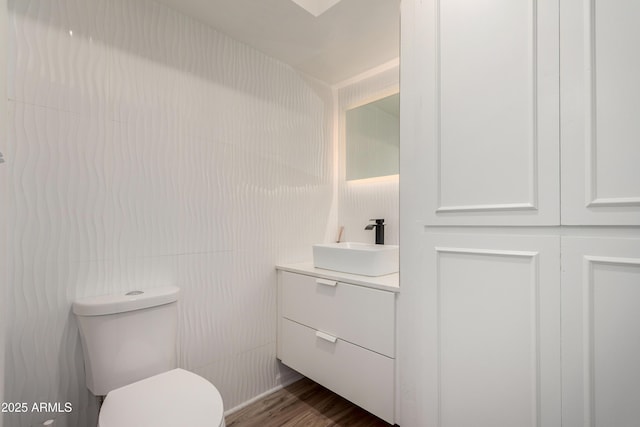 bathroom featuring vanity, wood finished floors, and toilet