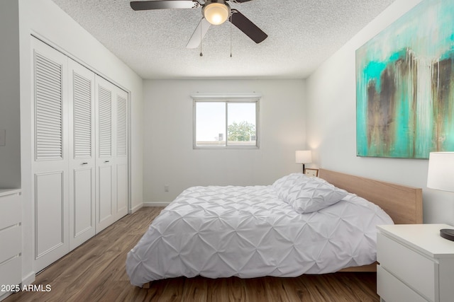 bedroom with a closet, a textured ceiling, ceiling fan, and wood finished floors