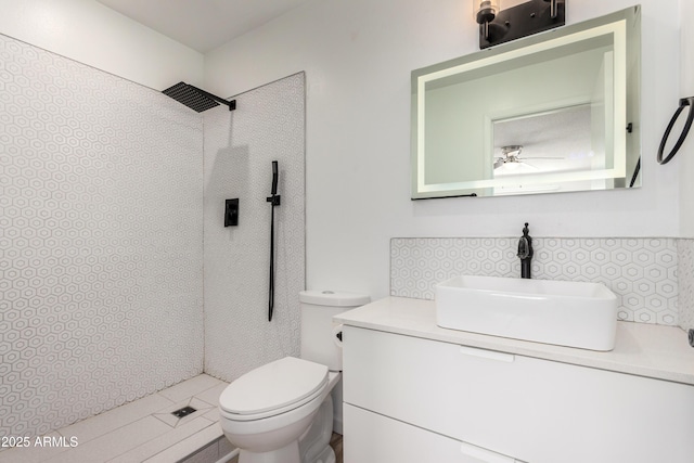 full bath with vanity, a ceiling fan, a tile shower, and toilet