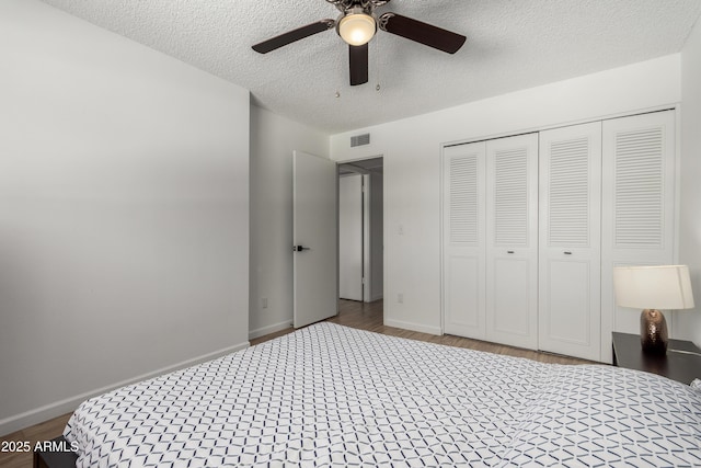 unfurnished bedroom with visible vents, baseboards, a textured ceiling, and wood finished floors