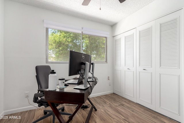 home office with baseboards, a ceiling fan, a textured ceiling, and wood finished floors