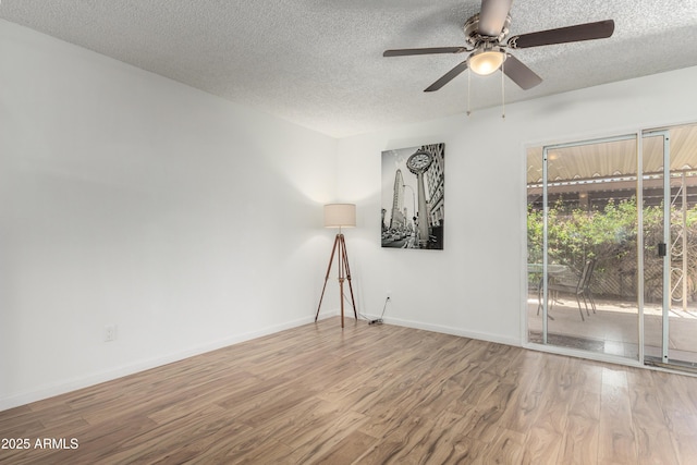 spare room featuring a textured ceiling, baseboards, a ceiling fan, and wood finished floors