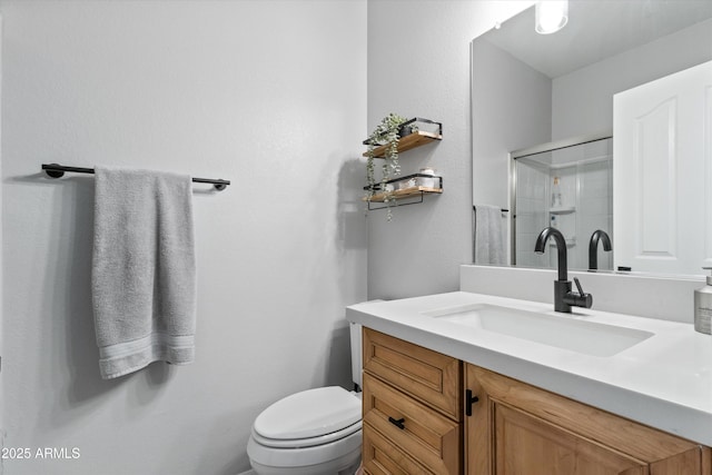 bathroom featuring vanity, toilet, and a shower with shower door