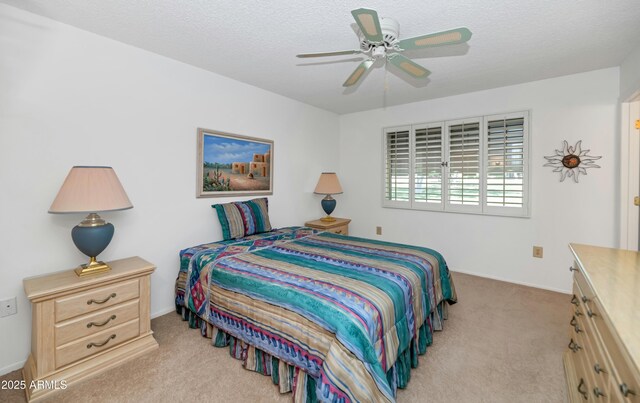bedroom with light carpet, a textured ceiling, and baseboards