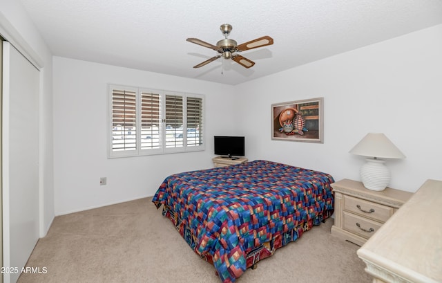 carpeted bedroom featuring a closet, baseboards, and a ceiling fan