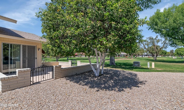 exterior space with fence, a gate, and a lawn