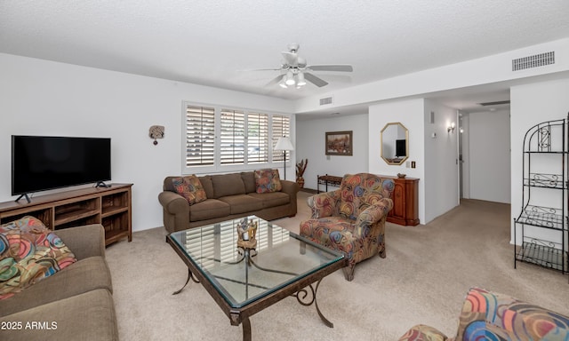 living area featuring a textured ceiling, light colored carpet, ceiling fan, and visible vents