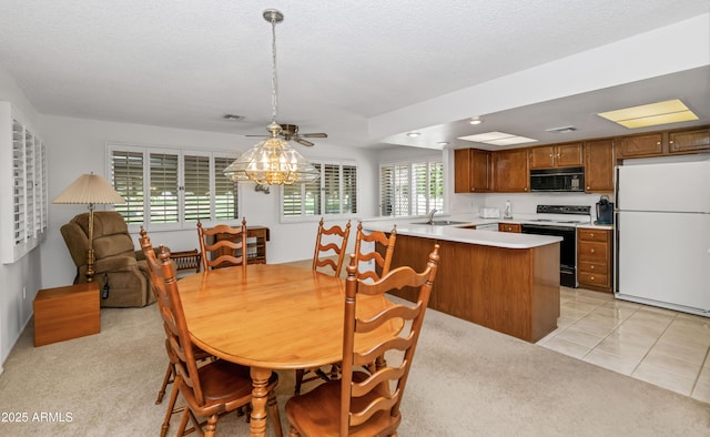 dining room with light tile patterned floors, visible vents, and a ceiling fan