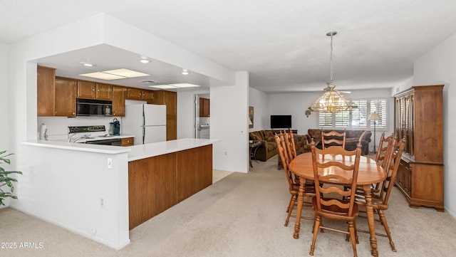dining space featuring recessed lighting, an inviting chandelier, and light carpet