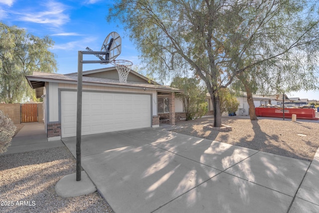 view of front of home featuring brick siding, concrete driveway, a garage, and fence