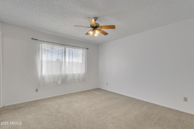 carpeted empty room featuring baseboards, a textured ceiling, and a ceiling fan