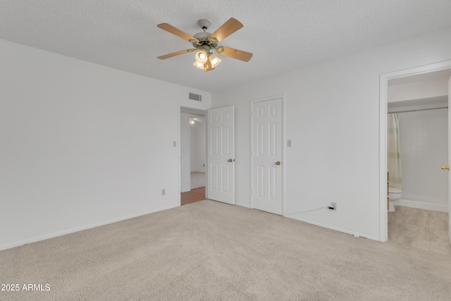 unfurnished bedroom with visible vents, carpet, and a textured ceiling