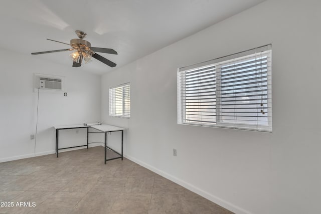 empty room featuring a wall mounted air conditioner, baseboards, and ceiling fan