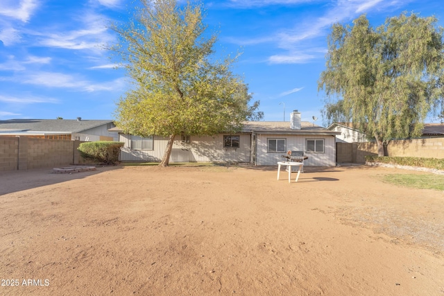 rear view of property with a patio, fence, and a chimney