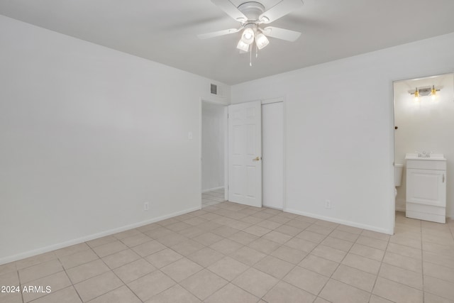 tiled empty room featuring ceiling fan and sink