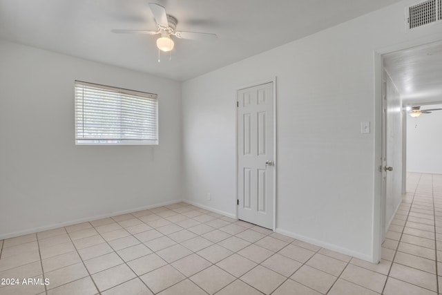 spare room with ceiling fan and light tile patterned floors