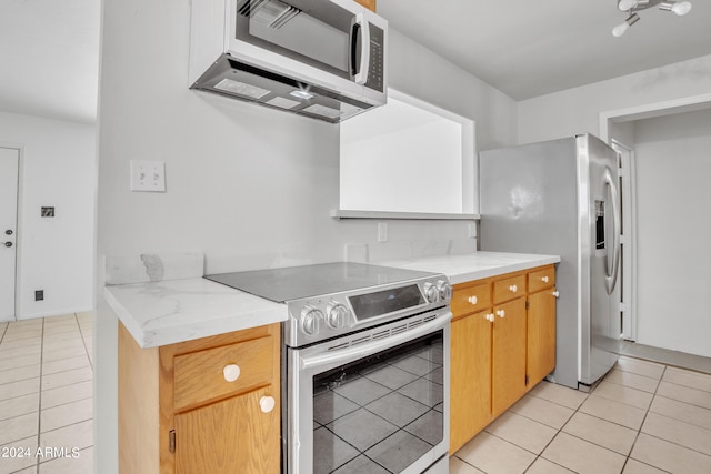 kitchen featuring appliances with stainless steel finishes and light tile patterned flooring