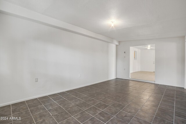 empty room with dark tile patterned flooring