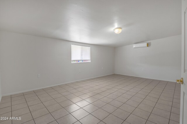 spare room with an AC wall unit and light tile patterned flooring