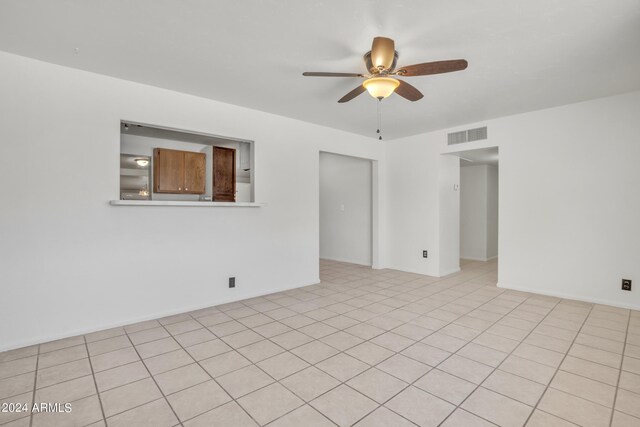 tiled spare room with ceiling fan