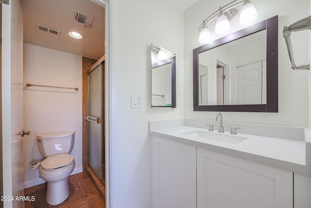 bathroom with an enclosed shower, tile patterned floors, toilet, and vanity