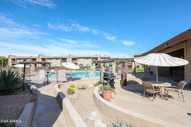 view of pool with a pergola, area for grilling, and a patio