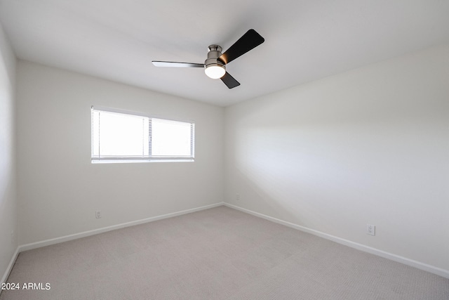 spare room featuring light colored carpet and ceiling fan