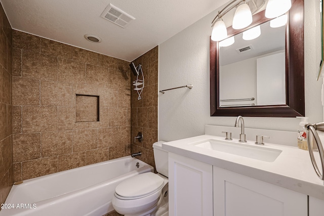 full bathroom featuring toilet, tiled shower / bath combo, a textured ceiling, and vanity