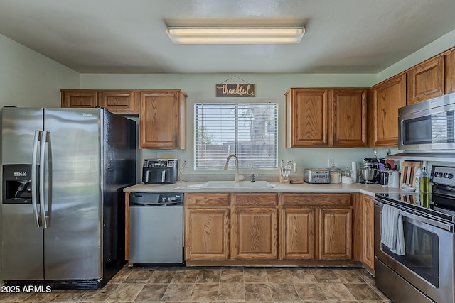 11101 E Abilene Ave, Mesa, AZ 85208 - kitchen featuring stainless steel appliances, light countertops, brown cabinets, and stone finish floors