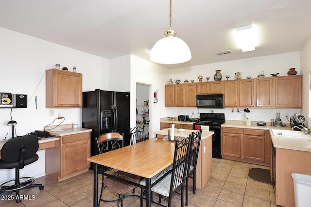 kitchen with sink, decorative light fixtures, black appliances, and light tile patterned floors