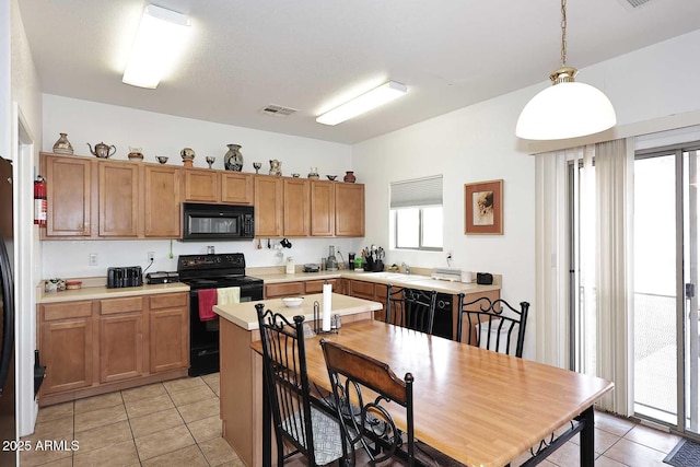 kitchen featuring sink, decorative light fixtures, light tile patterned floors, and black appliances