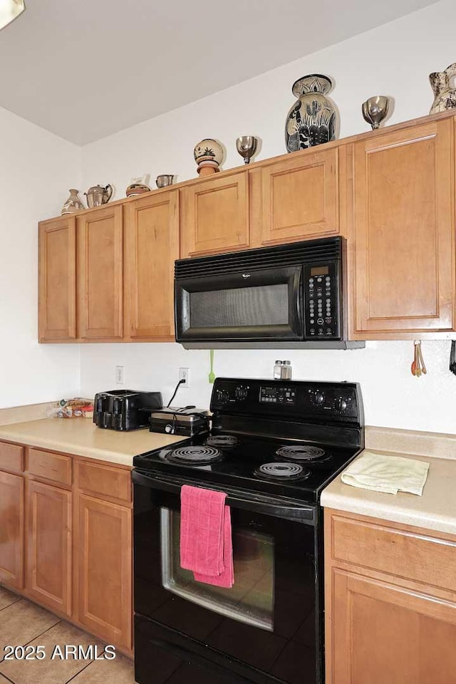 kitchen with light tile patterned flooring and black appliances