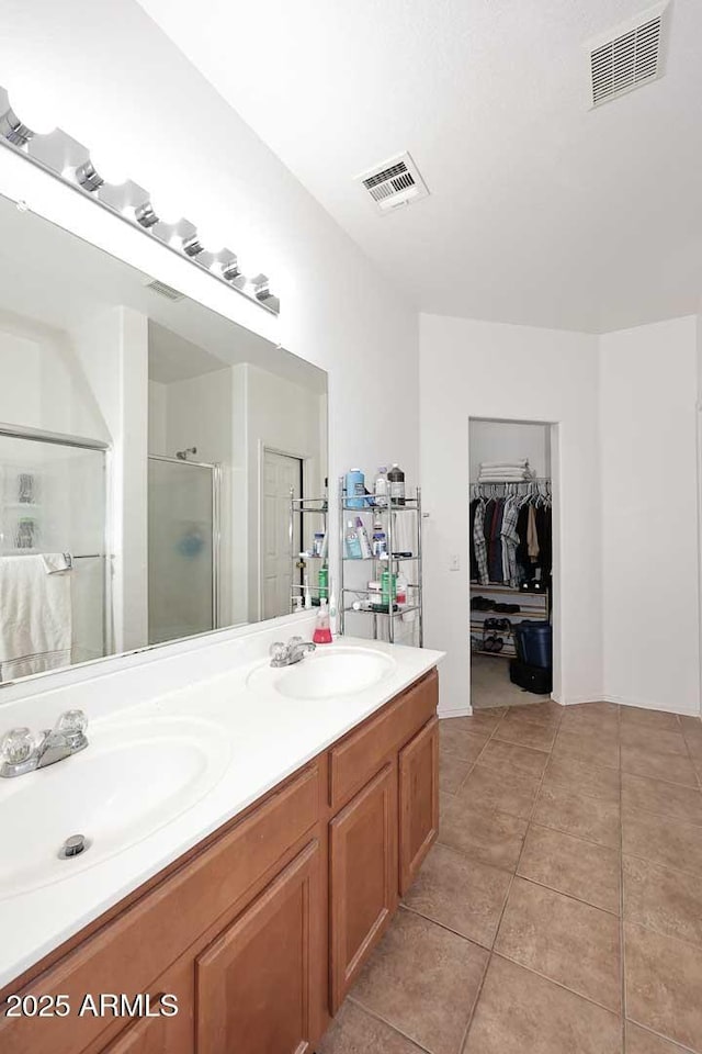 bathroom with tile patterned floors, an enclosed shower, and vanity