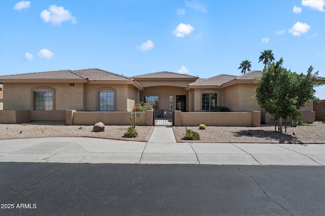 24403 N 43rd Dr, Glendale, AZ 85310 - view of front of home with a fenced front yard, a tile roof, a gate, and stucco siding