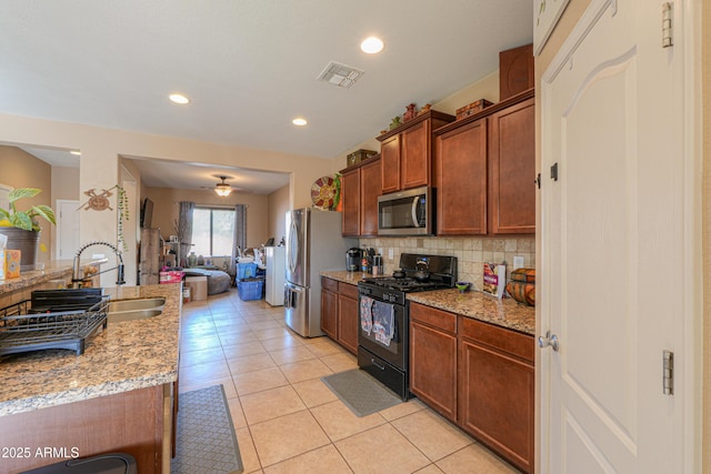 kitchen featuring visible vents, decorative backsplash, light tile patterned flooring, light stone countertops, and stainless steel appliances
