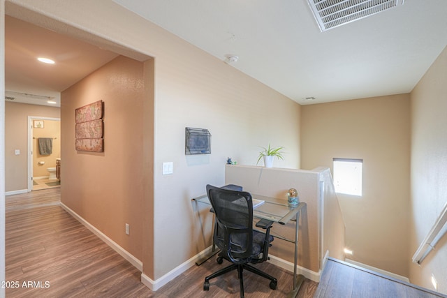 office space with baseboards, wood finished floors, and visible vents