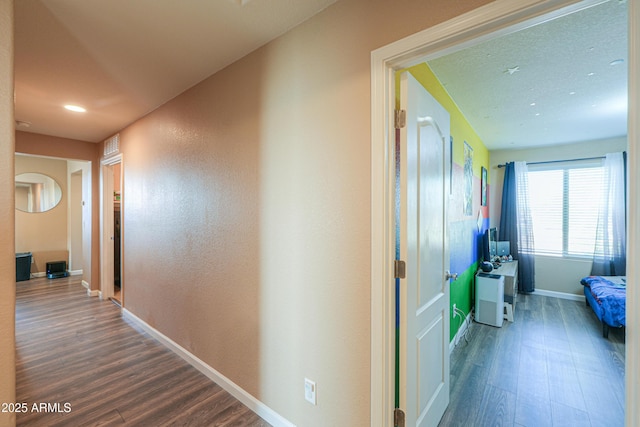 corridor with baseboards, recessed lighting, and wood finished floors