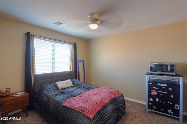 carpeted bedroom featuring visible vents, baseboards, and ceiling fan