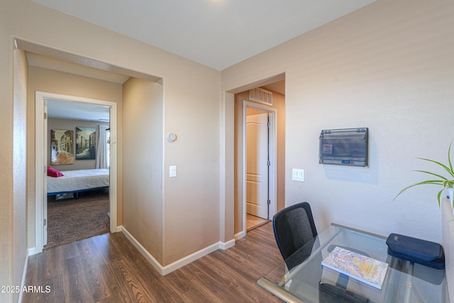 home office with baseboards and dark wood-type flooring